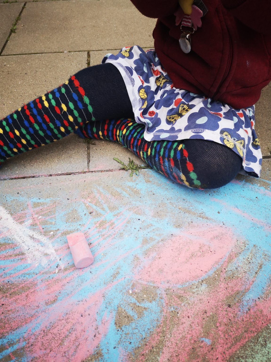 Kind mal mit Kreide auf den Boden.