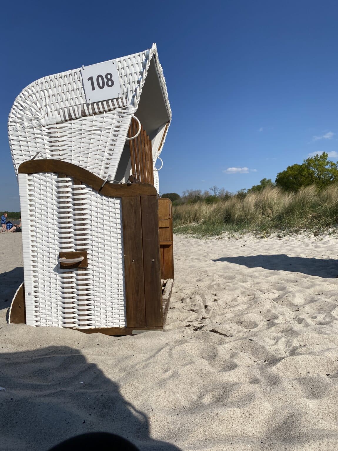 #11 Es ist Strandzeit für mich. Da es windig ist, habe ich eher mehr angezogen und versuche im Windschatten zu sitzen..