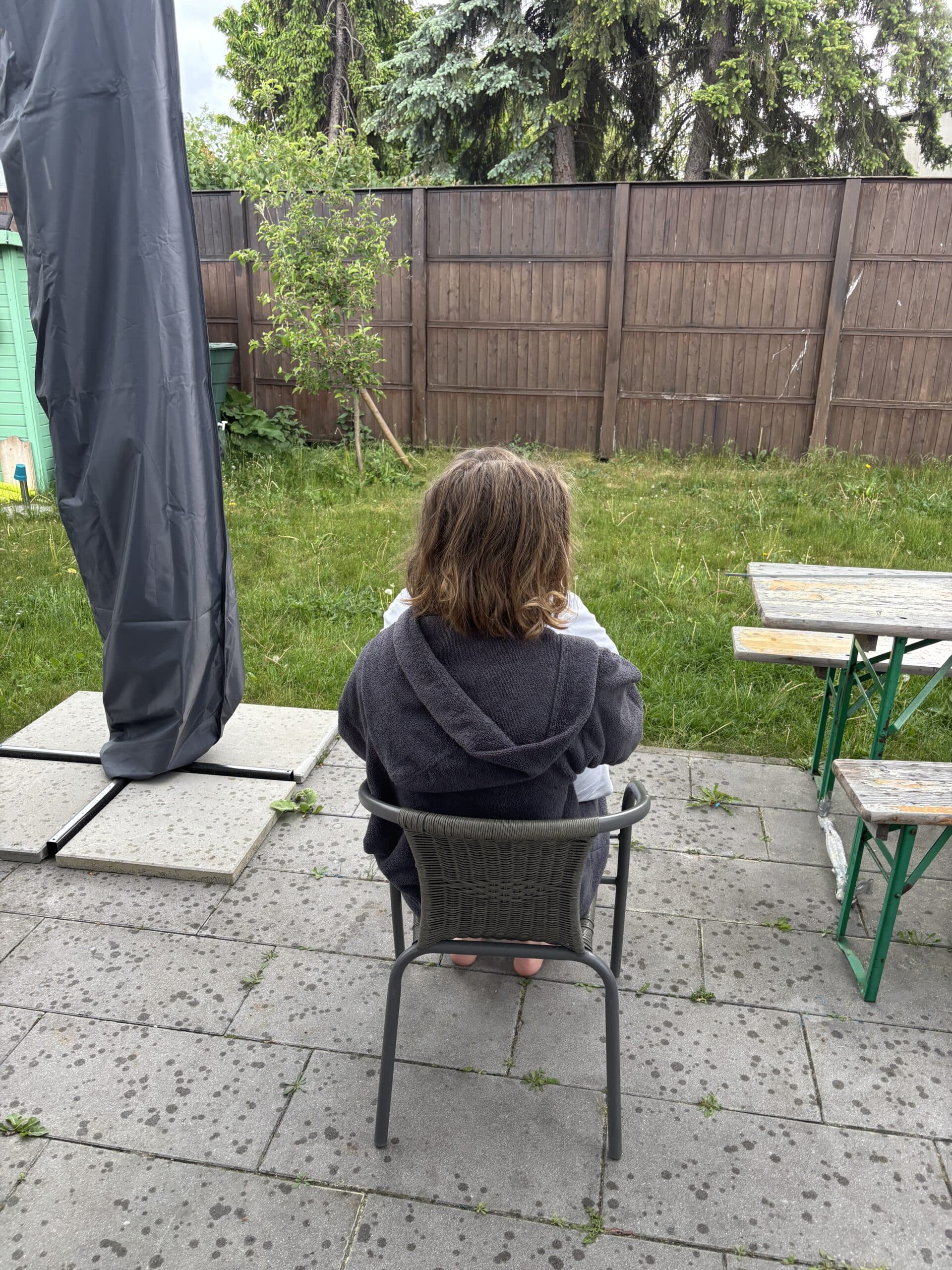 Die Kinder schauen im Nieselregen nach Stieglitzen und Spechten.
