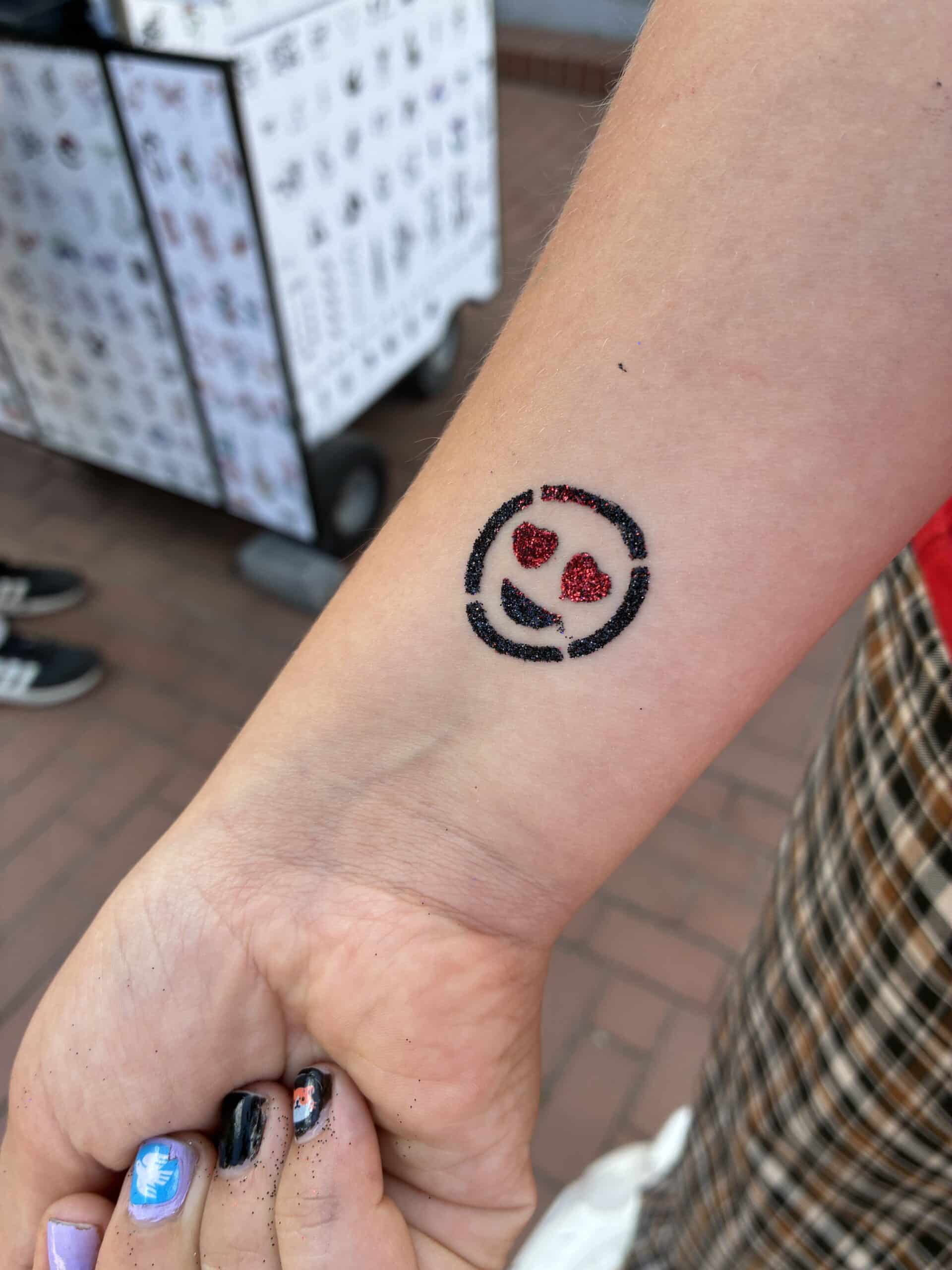 Das Kind sucht sich ein Tattoo aus, für das neue Schuljahr.